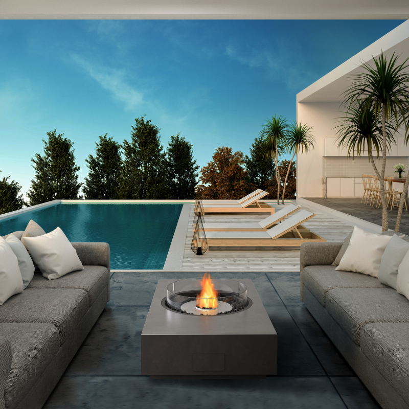 EcoSmart Martini 50 fire table positioned poolside with the sunken circular flame lit at dusk.