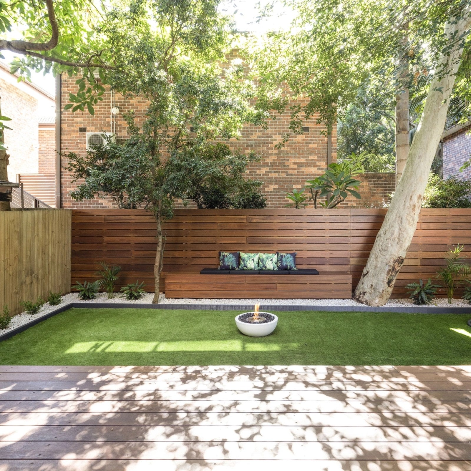 EcoSmart Mix 600 fire pit bowl on a lawn in a landscaped backyard garden.