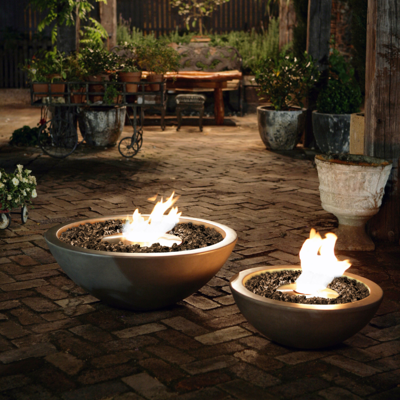 EcoSmart Mix 600 Fire Pit in Natural concrete finish glowing at night in a garden patio setting.