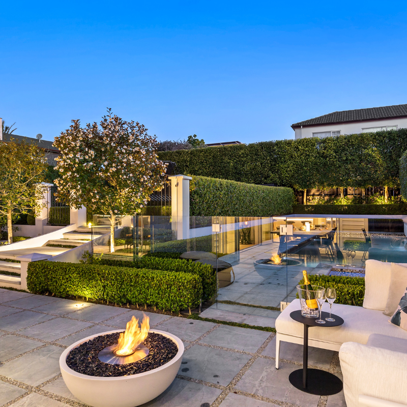 EcoSmart Mix 850 Fire Pit on a luxury poolside patio at dusk with seating and outdoor entertaining.