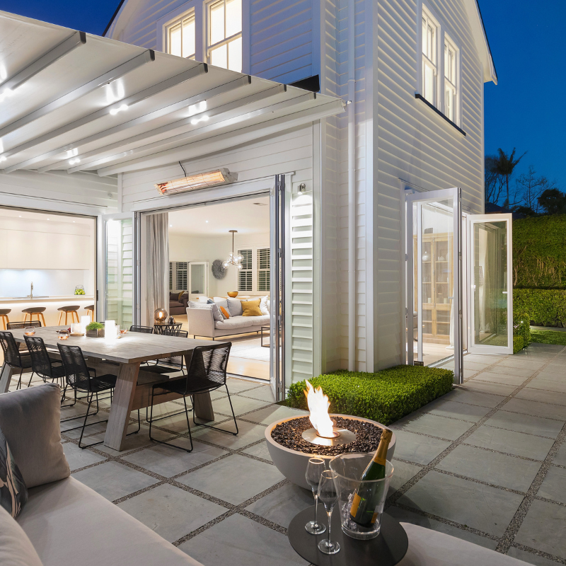EcoSmart Mix 850 Fire Pit on a modern patio at night with dining area and seating.