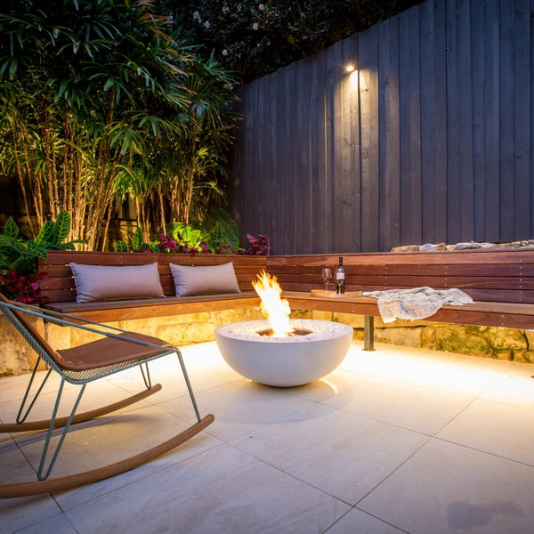 EcoSmart Mix 850 fire pit bowl lit at dusk in a Sydney courtyard with timber bench seating and uplit planting.