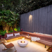 EcoSmart Mix 850 Fire Pit glowing on a corner patio with timber bench seating and landscaped garden.