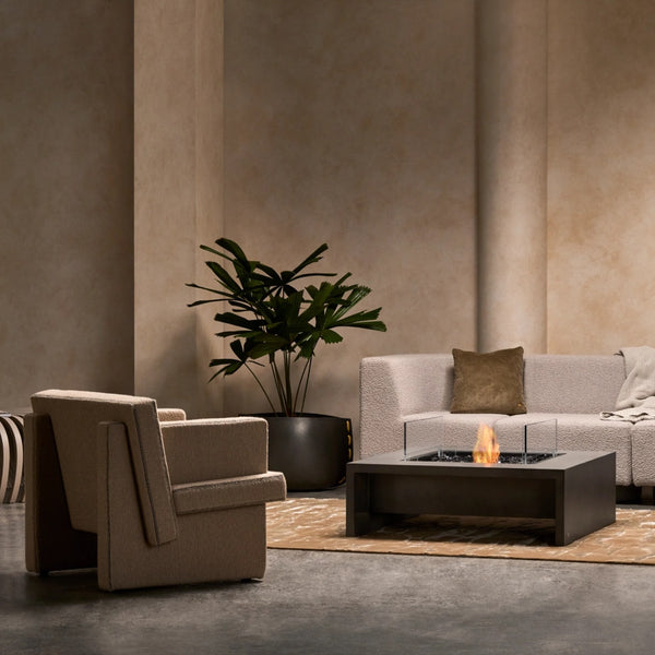 EcoSmart Mojito 40 fire table in a warm minimalist lounge with a boucle sofa and armchair.