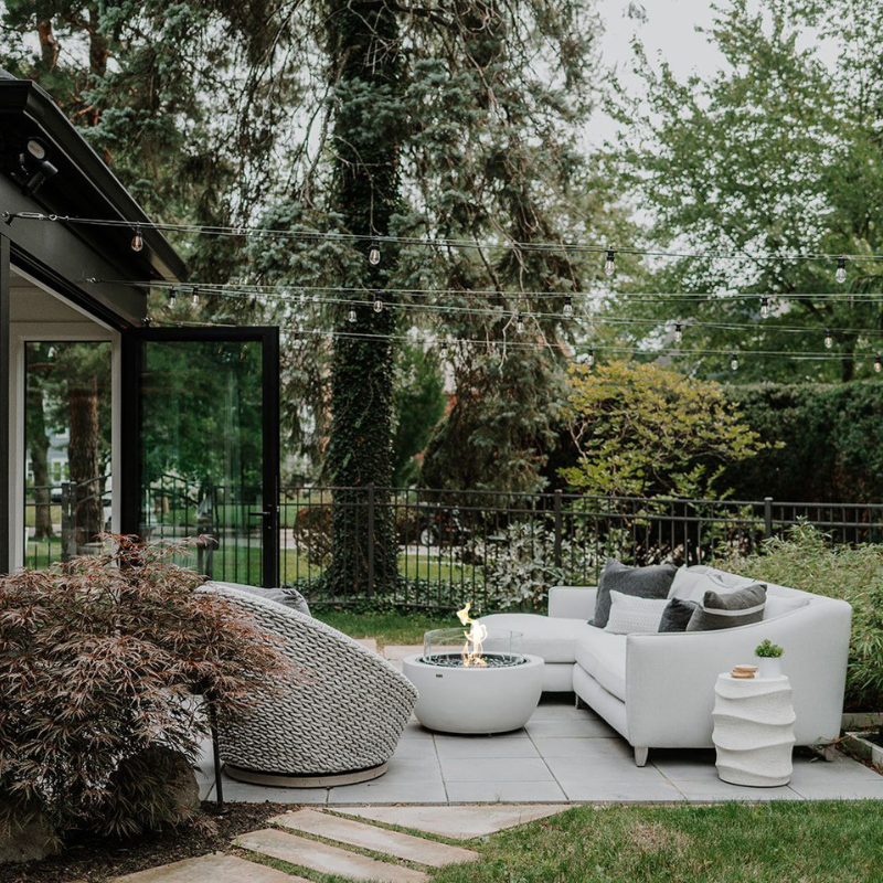 EcoSmart Pod 30 Fire Pit in a backyard entertaining area with designer outdoor furniture.