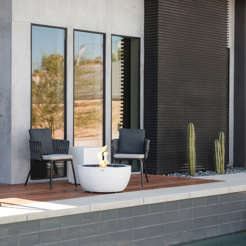 EcoSmart Pod 30 Fire Pit beside a modern pool patio with outdoor lounge chairs.