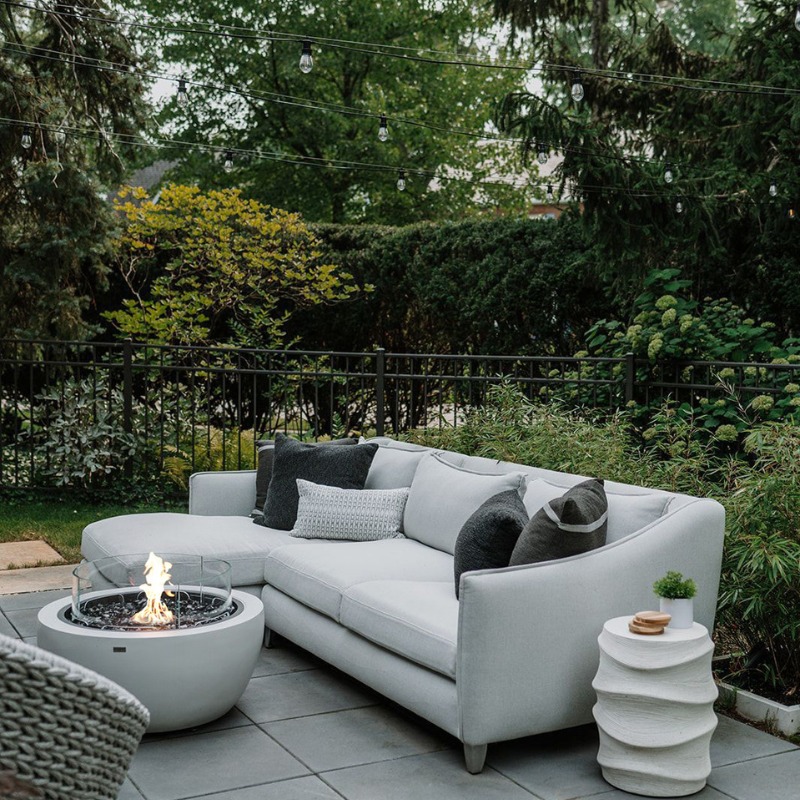 EcoSmart Pod 30 Fire Pit in a garden lounge setting with outdoor sofa.