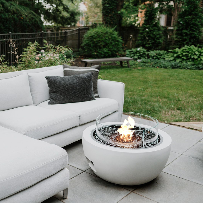 EcoSmart Pod 30 Fire Pit on a patio beside modern outdoor sofa seating.