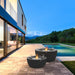 EcoSmart Pod 40 fire pit bowls lit on a poolside deck at dusk beside a modern home.