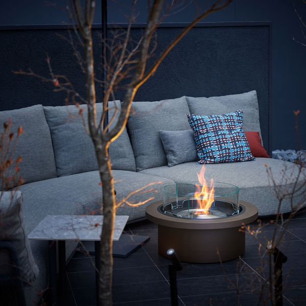 EcoSmart Round 20 set into a round garden table beside outdoor lounge seating at night
