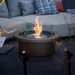 EcoSmart Round 20 Fire Pit Kit placed in an outdoor setting, surrounded by contemporary seating and glass elements, creating an elegant atmosphere.