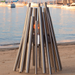 EcoSmart Stix Fire Pit closeup lifestyle image on sandy beach with marina backdrop