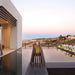 EcoSmart Stix fire pits lit beside an infinity pool on a modern home terrace at dusk.