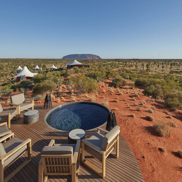 EcoSmart Stix fire pit at Longitude 131 luxury desert camp overlooking Uluru, with a plunge pool and lounge seating.
