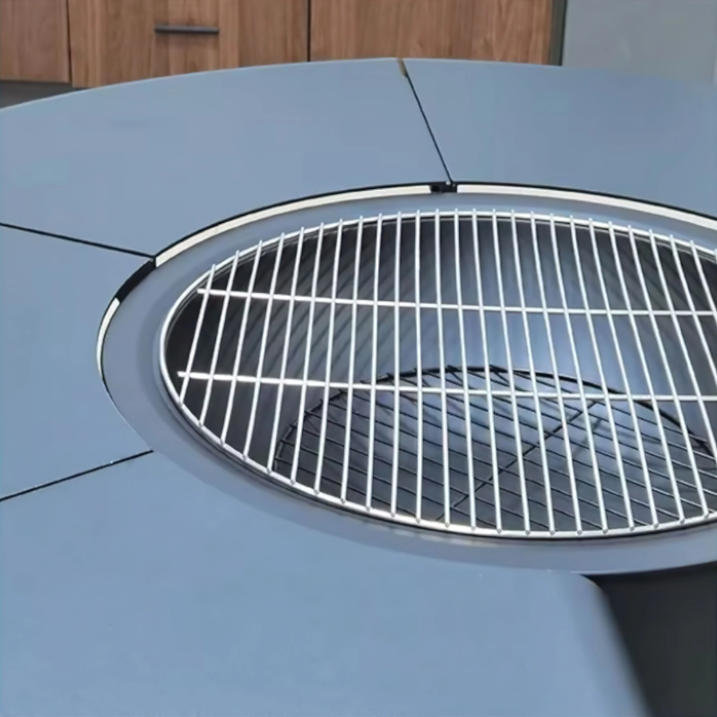 Close-up of the Fabrizio Fire Pit in Australia showing the circular steel top and integrated grill grate insert, photographed indoors to highlight the cooking surface and fire bowl opening
