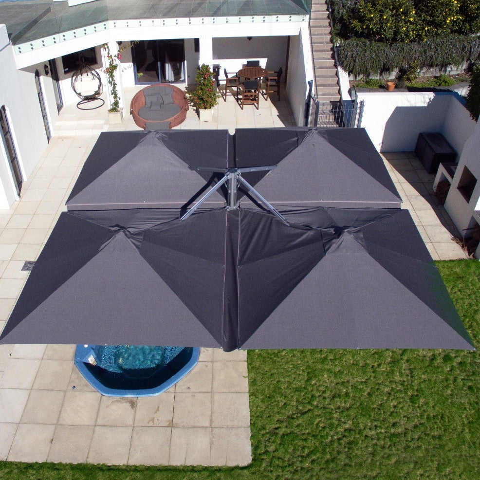 Aerial view of a Unity Quattro four panel umbrella configuration over a pool