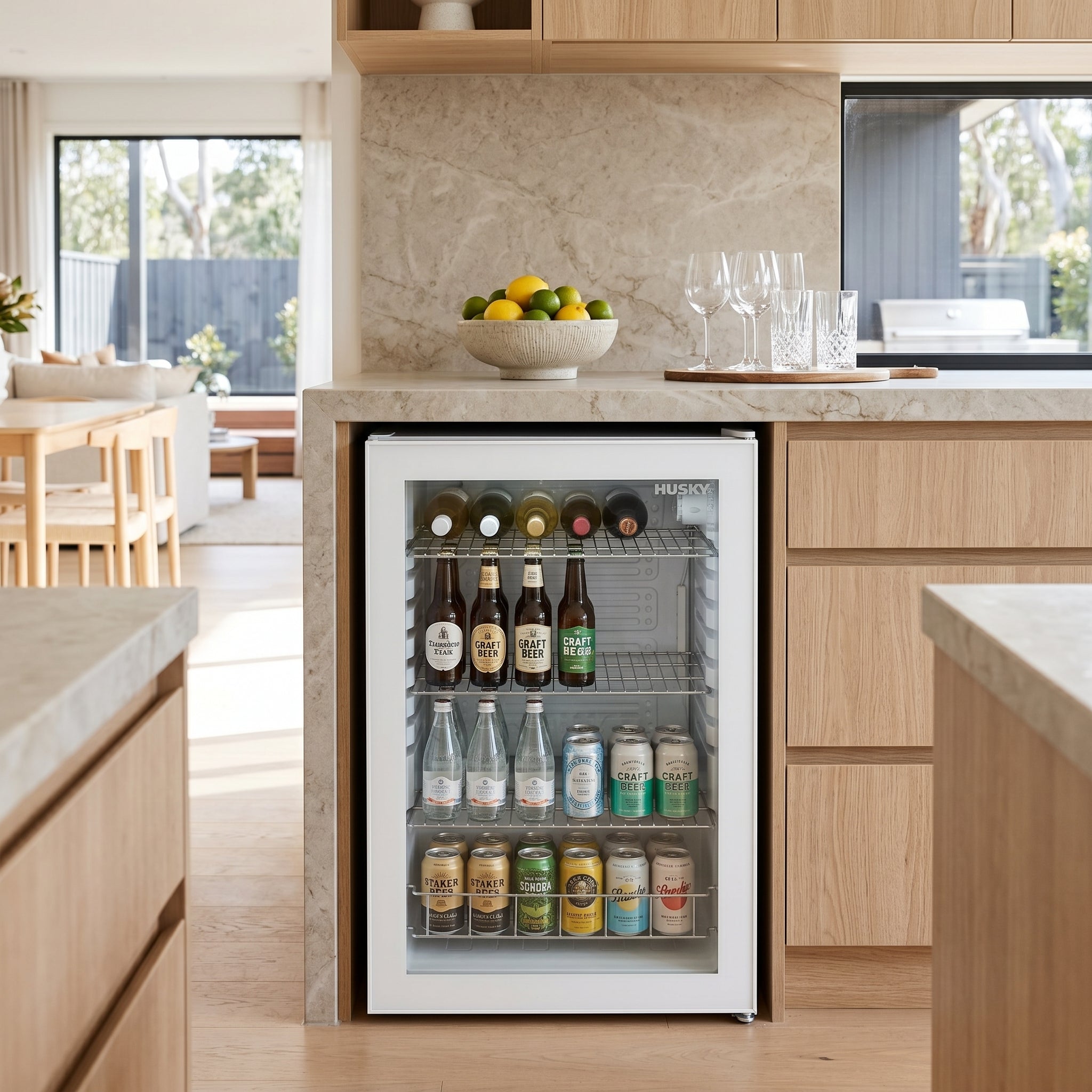 Husky 130L glass door bar fridge built in under a kitchen benchtop stocked with drinks