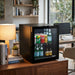Husky 48L mini glass door bar fridge on a study credenza stocked with cans and drinks