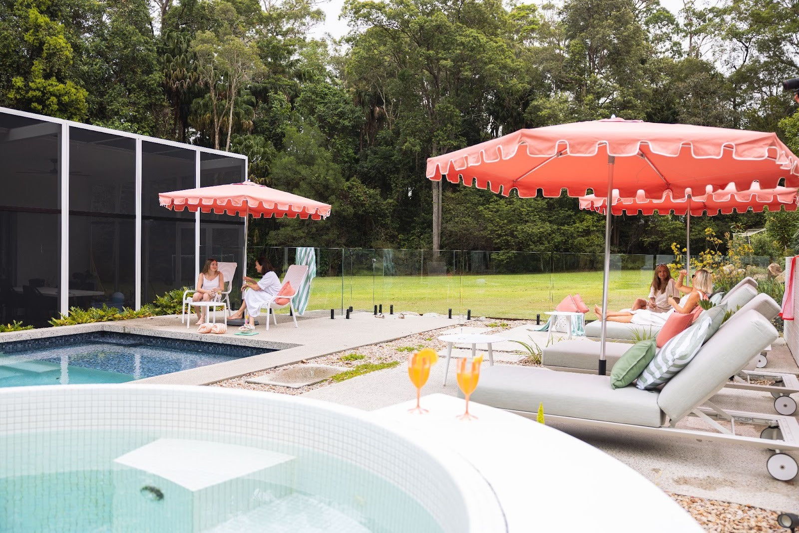 Villa valance umbrella, Musk canopy, poolside lifestyle setting with two umbrellas