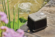 Oase AquaOxy 2500 air pump beside a garden pond