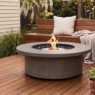 EcoSmart Mimosa 40 Fire Table in Natural / Stainless Steel on a wooden deck with a timber bench, cushion, throw, and wisteria — Australian afternoon light