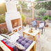 Front view of the Ochre Living Hotham Complete Fireplace Kit installed in a garden patio under string lights with surrounding plants, chairs, and wood storage, showing an outdoor fireplace with chimney Australia.