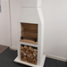 Front view of the Ochre Living Ossa Complete Fireplace Kit displayed indoors in a showroom, with stacked firewood below and a cooking grill fitted inside the firebox.