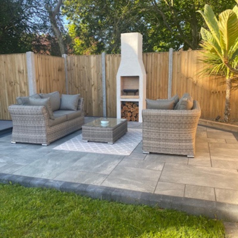 Modern patio setup featuring the Ochre Living Ossa Complete Fireplace Kit with chimney, surrounded by outdoor lounge seating and paving, showing a clean and contemporary outdoor fireplace design ideal for Australian backyards.