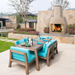 Ochre Living Perisher Complete Fireplace Kit integrated into an outdoor dining area beside a stone wall, adding warmth and ambience to a landscaped luxury backyard