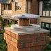 Ochre Living Rain Cap fitted on a brick chimney in a residential home setting, showing the raised cap design and ventilation gap for smoke and weather protection