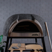 Front view of the charcoal finish Polito Antonius Garden Wood Fired Oven with timber pizza peels and pizza oven tools displayed beneath the cooking chamber