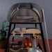 Front view of the charcoal Polito Antonius Garden Wood Fired Oven with stainless steel door, pizza oven tools, timber peels, firewood bucket, and preparation accessories