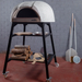 Polito Antonius Garden Wood Fired Oven styled with a Polito pizza oven stand, stacked firewood, pizza thermometer, peels, and stainless steel pizza tools beside the oven