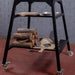 Polito Antonius Tower Stand in black steel with two shelves and four castors; the peels, pan and firewood shown are not included
