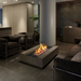 EcoSmart Cosmo 50 fire table in Natural concrete, used as an indoor centrepiece in a modern living room with dark seating.
