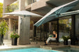 Shadowspec Retreat wall-mounted umbrella in a courtyard beside a pool