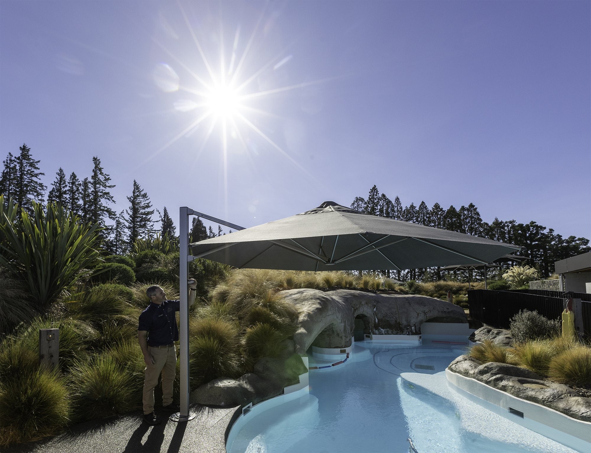Shadowspec Serenity cantilever umbrella beside a pool in full sun
