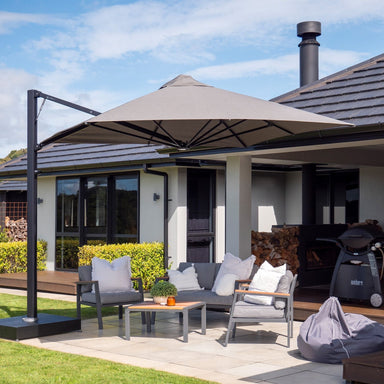 Shadowspec SU4 square offset umbrella with grey canopy over an outdoor lounge setting