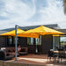 Shadowspec Unity twin-canopy cantilever umbrella in yellow over an outdoor lounge