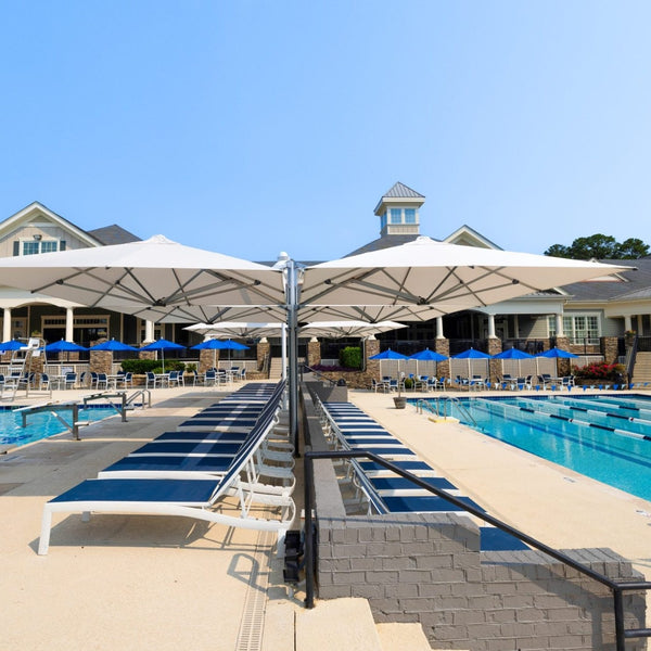 Shadowspec Unity Quattro umbrella, four Oyster canopies on a Space Grey frame, over a pool deck