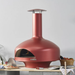 Shimmering Rose Polito Giotto Oven BTS freestanding outdoor pizza oven displayed on a stone bench with pizza making ingredients and accessories in a contemporary entertaining space