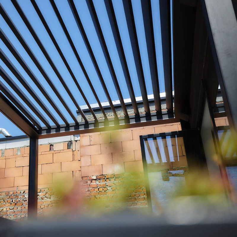 Upward view of a black SkyFlex Delta motorised aluminium louvred pergola with open roof slats