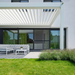 White SkyFlex Delta motorised aluminium louvred pergola attached to a modern home above an outdoor seating area