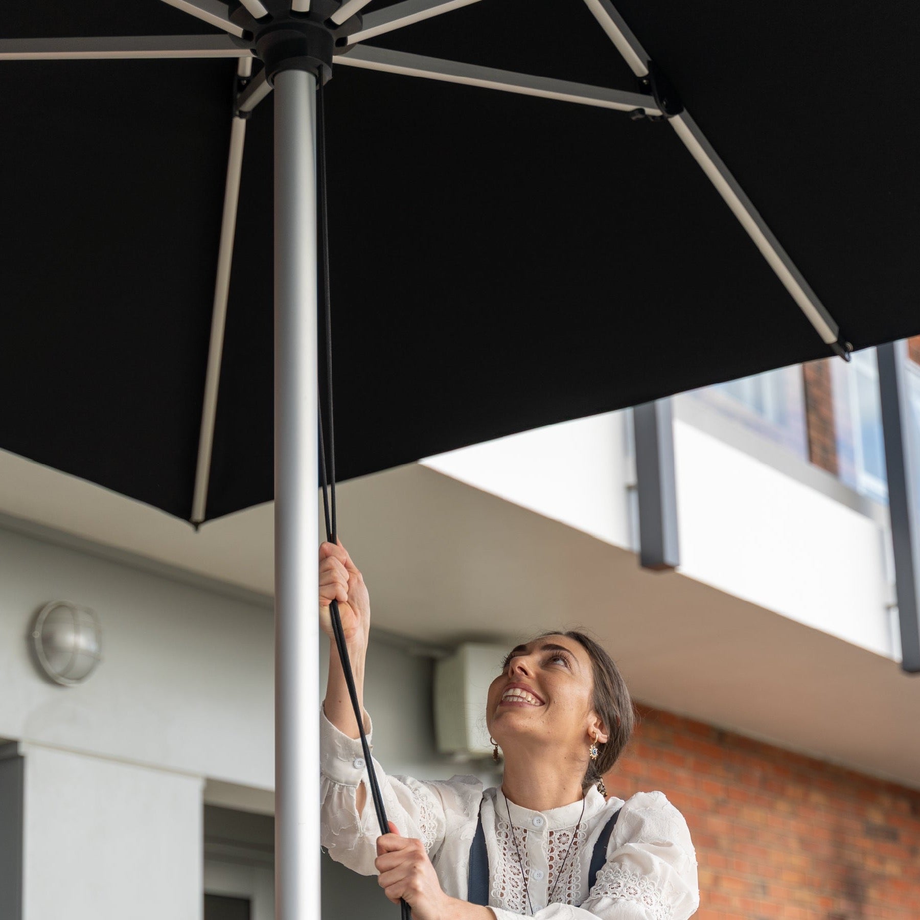 Opening the Shadowspec Oasis umbrella on its spigot and surface plate mount