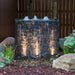 Curved Stacked Slate Spillway Wall fountain at night, lit with spotlights sold separately