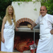 Lifestyle shot showing the elegant Valoriani pizza oven in a rustic outdoor kitchen setup