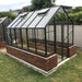 Winter Gardenz Elite 8ft x 12ft glasshouse with black aluminium frame, glass roof and autovents on a brick base wall in a backyard