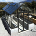 Winter Gardenz Elite 8ft x 16ft glasshouse on a rendered block base wall with mountain views