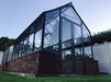 Winter Gardenz Elite 8ft wide glasshouse on a dark brick base wall, shown with a shade cover fitted